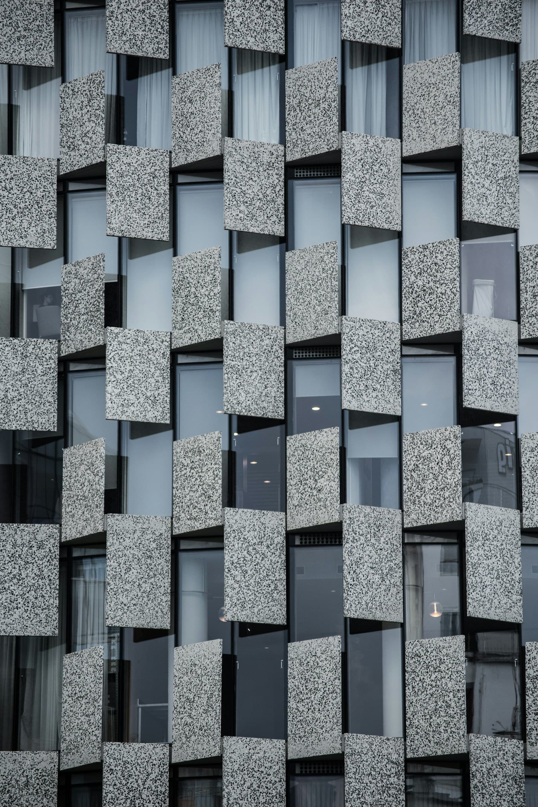 A modular stone and glass façade in raking light
